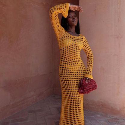 @coco_floflo wearing a orange crochet maxi dress