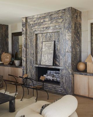 A monumental grey and white veined marble fireplace commands this room.
