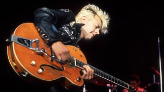 American Rockabilly and Rock musician Brian Setzer, of the group Stray Cats, plays guitar as he performs onstage at the Marcus Amphitheater, Milwaukee, Wisconsin, July 1, 1988.