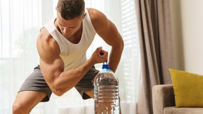 Man using a water bottle as a weight