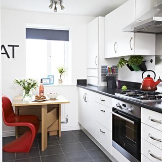 kitchen with red stacking chair and red kettle