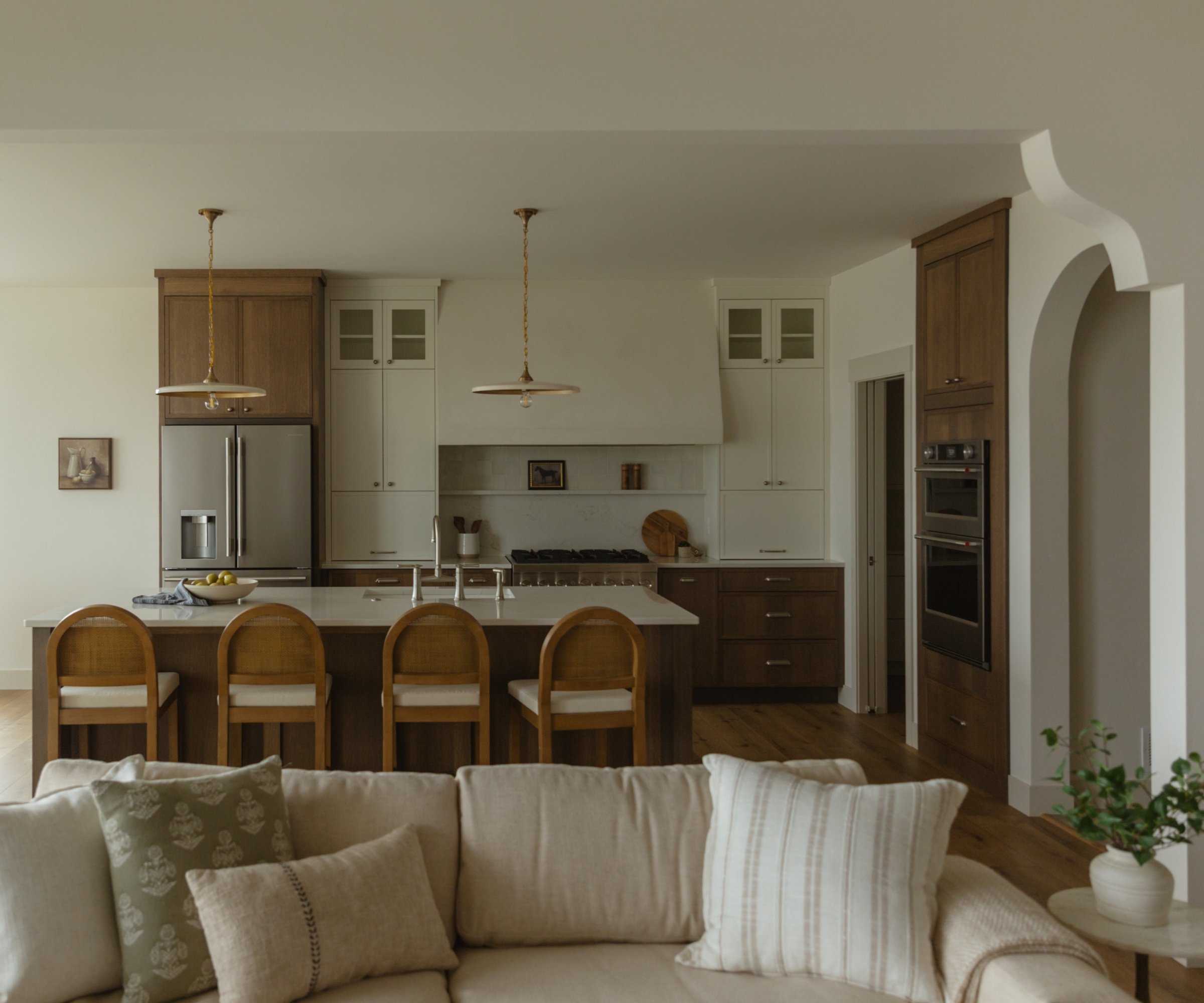 An open plan kitchen and living room with arched doorways and an ogee-inspired arch between the living room and kitchen