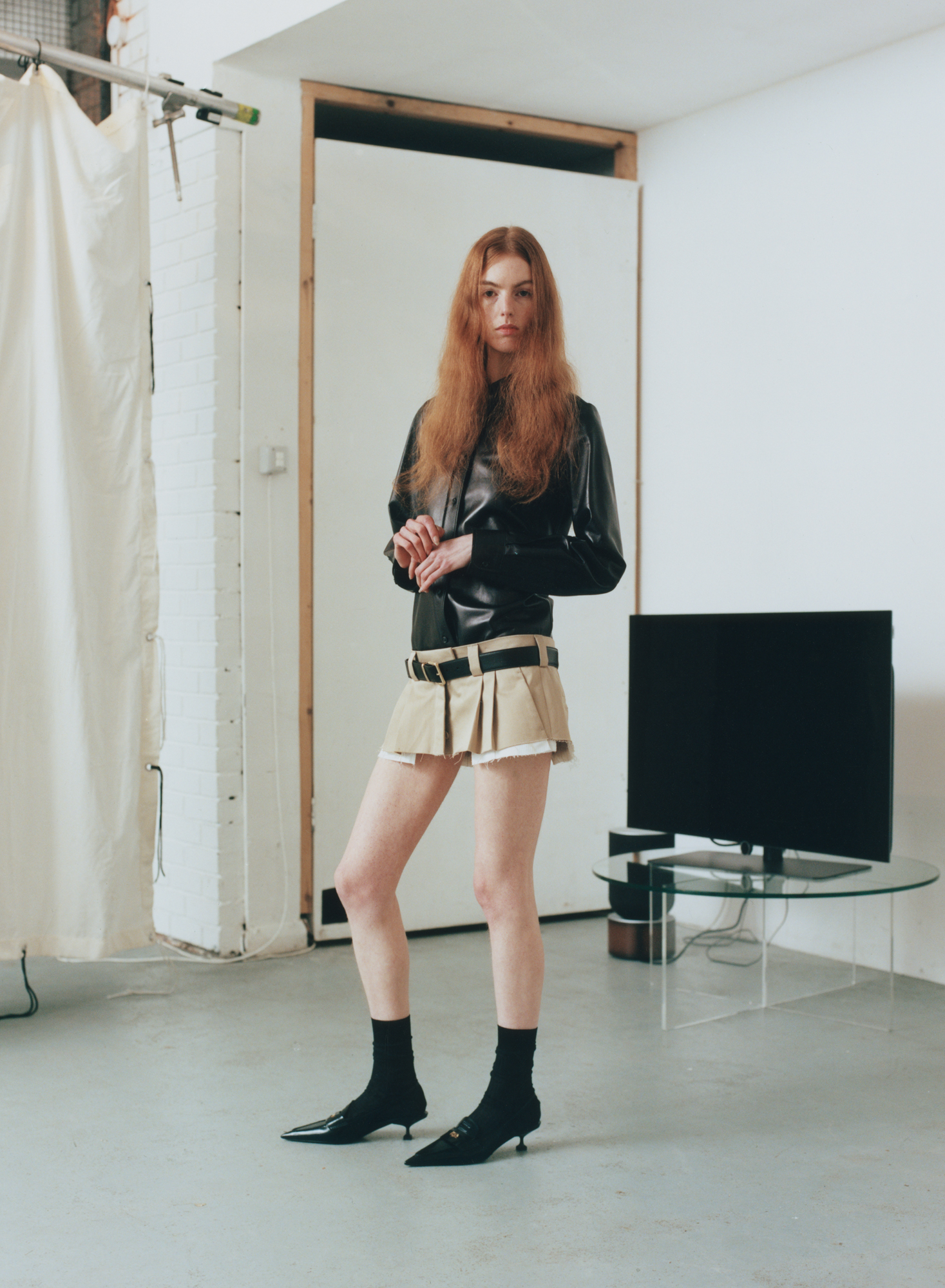 Woman in Miu Miu skirt with television