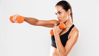 a photo of a woman doing punches with dumbbells