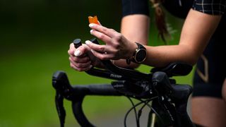 Hands on a bike handlebar’s holds an orange chew
