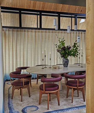 dining room with drape surrounding and blue patterned rug with purple leather wooden chairs and marble table