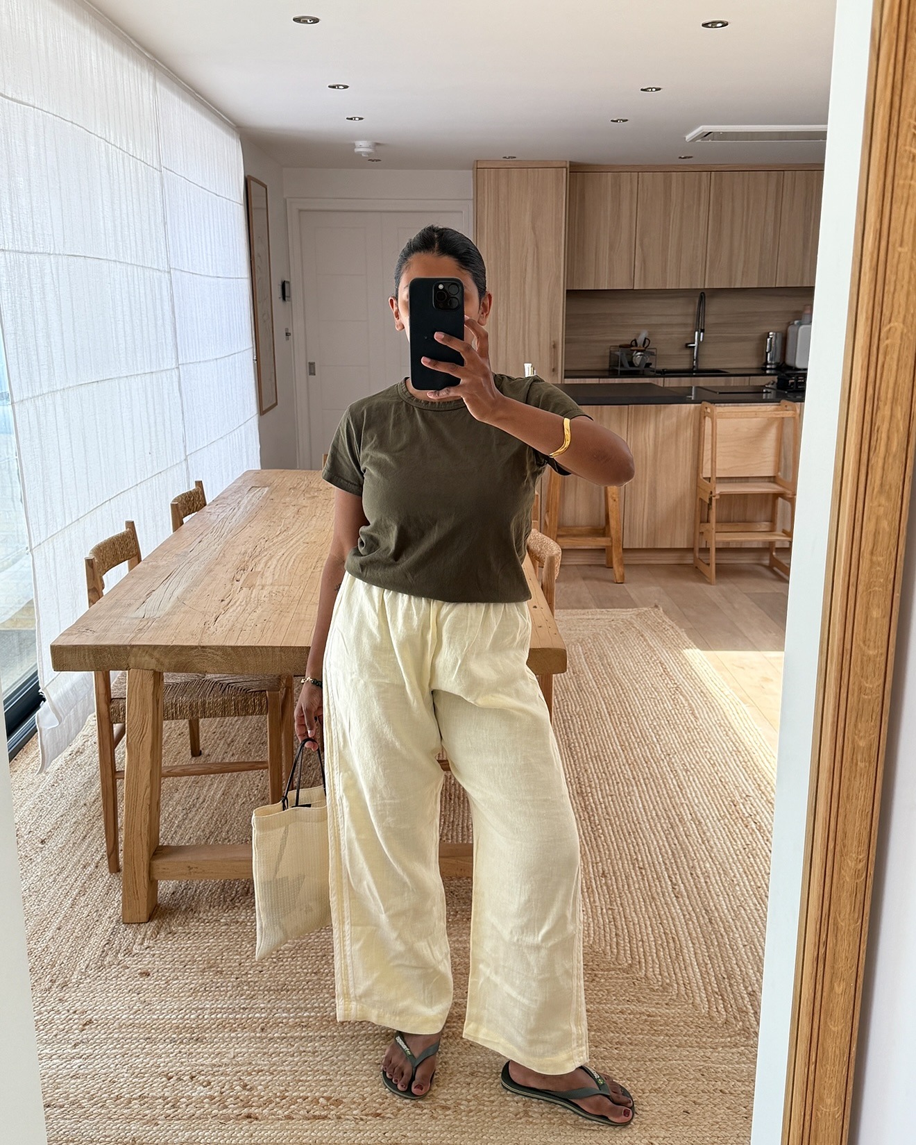 Monik wears a green tee, drawstring pants and green sandals.