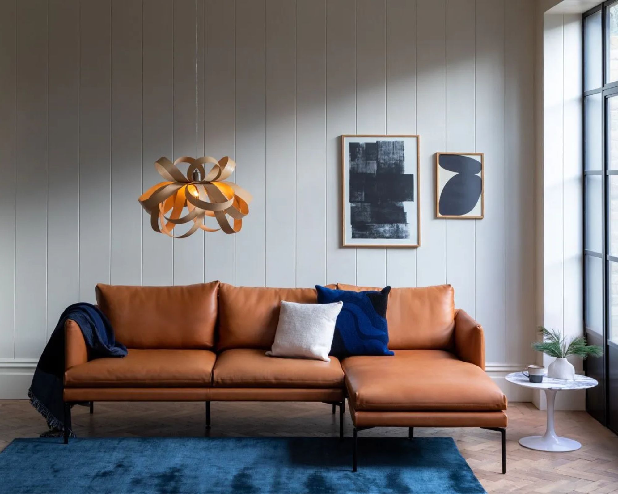Brown leather modern sofa with blue cushions