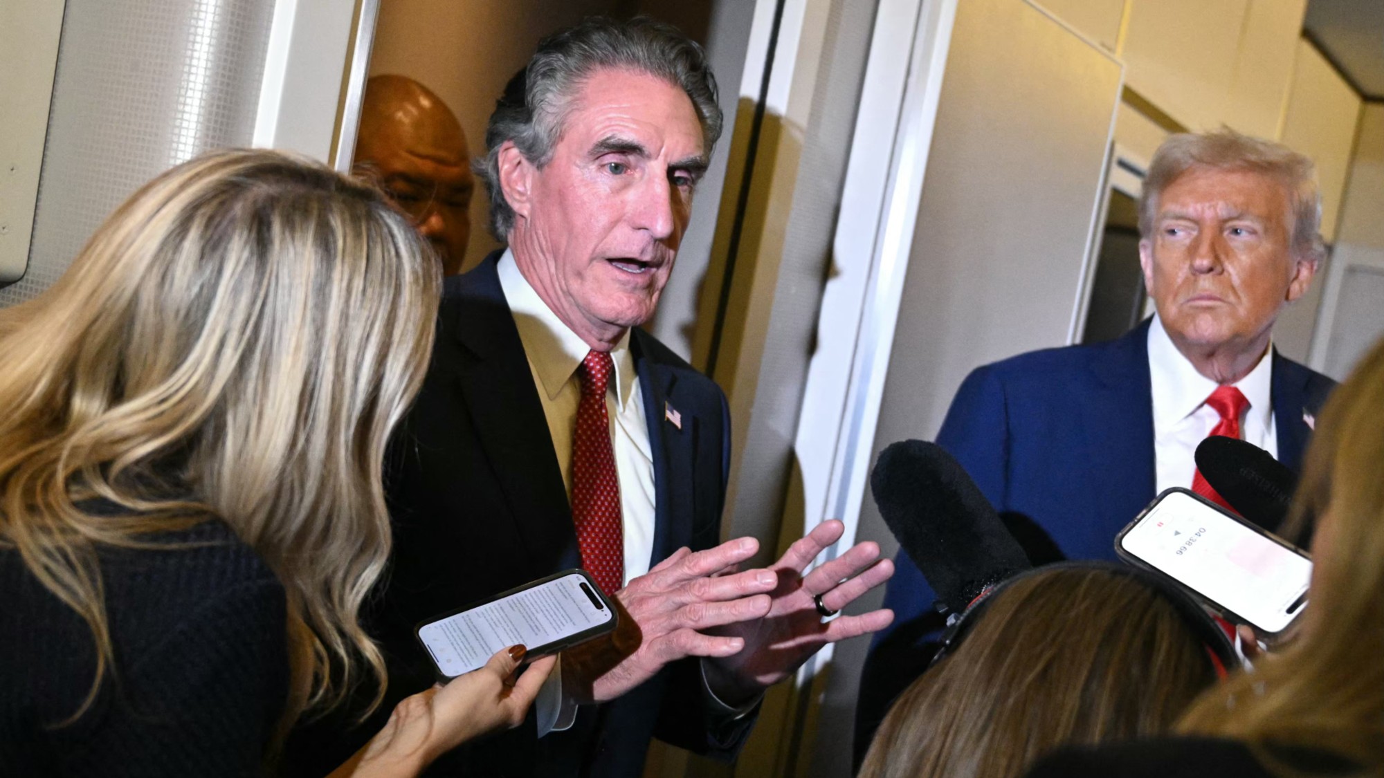 Secretary of the Interior Doug Burgum (L) speaks to reporters alongside US President Donald Trump while in flight on Air Force One, September 21, 2025