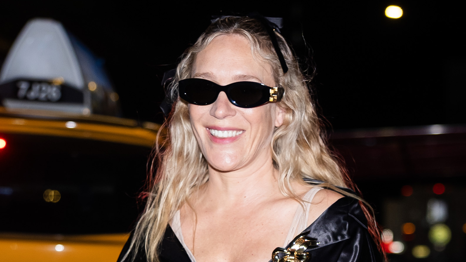 Chloë Sevigny wearing a black satin coat and sunglasses in NYC