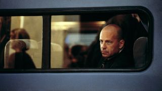 Bruce Willis looks out a train window in Unbreakable
