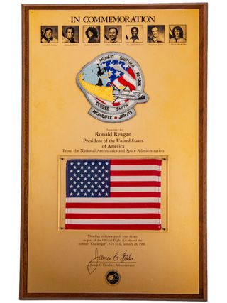 The chestnut and gold anodized aluminum plaque dedicated to the President of the United States, Ronald Reagan, included photos of the fallen crew and the NASA Administrator's signature.