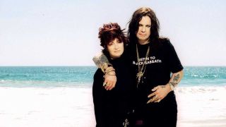 Sharon and Ozzy Osbourne posing on a beach with their backs to the sea