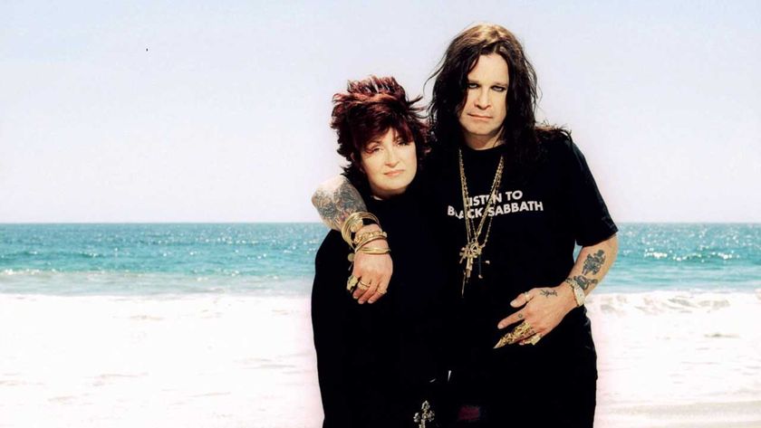 Sharon and Ozzy Osbourne posing on a beach with their backs to the sea