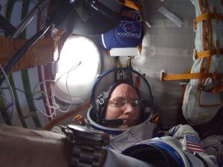 Scott Kelly by the window in a Soyuz spacecraft.