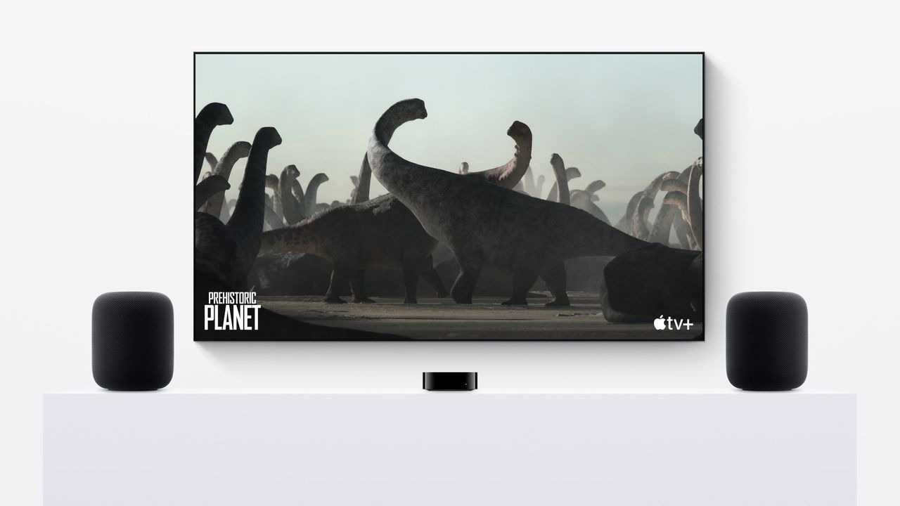 Two Apple HomePod 2 speakers on either side of a TV displaying Apple TV