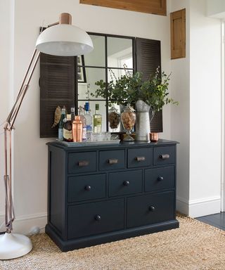 room with floor lamp and black desk with drawer
