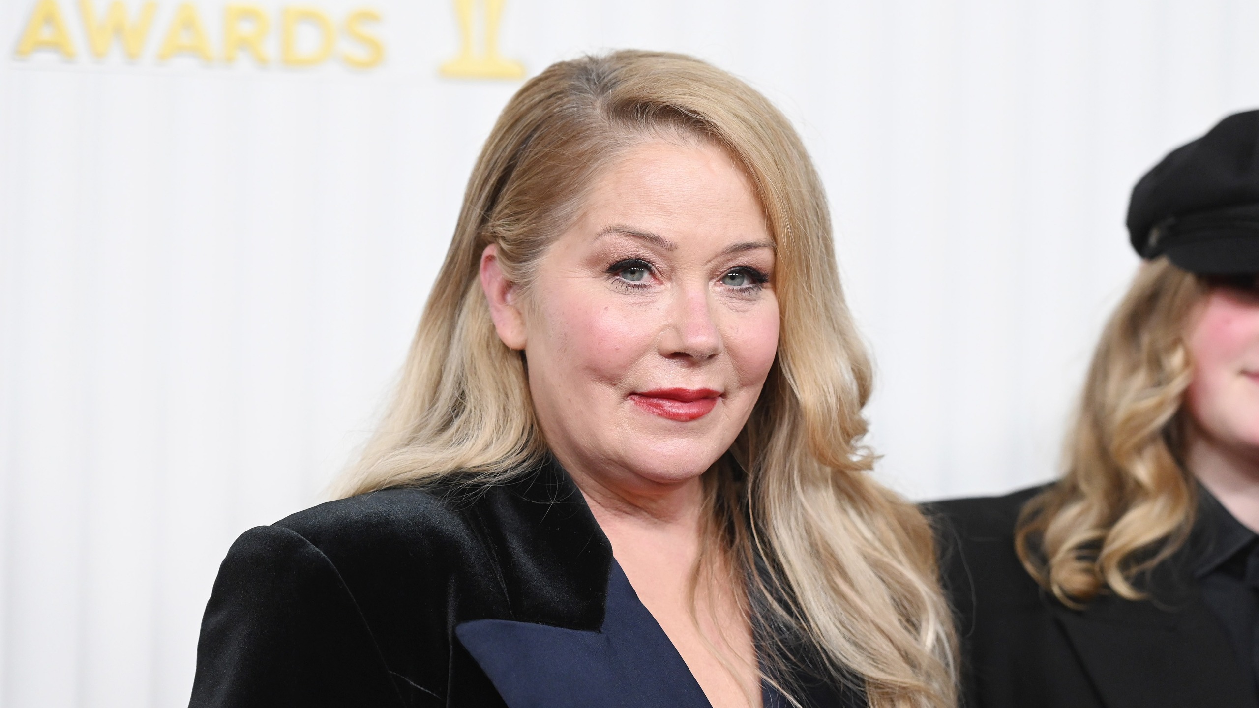 photo of christina applegate on a red carpet wearing a black velvet jacket