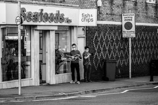 men waiting at chip shop street photography