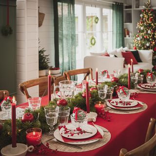 Christmas candle ideas with red table cloth and green garland