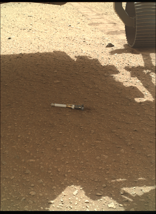 The first cached sample on Mars sits beside the Perseverance rover wheel in a picture made public on Dec. 21, 2022.
