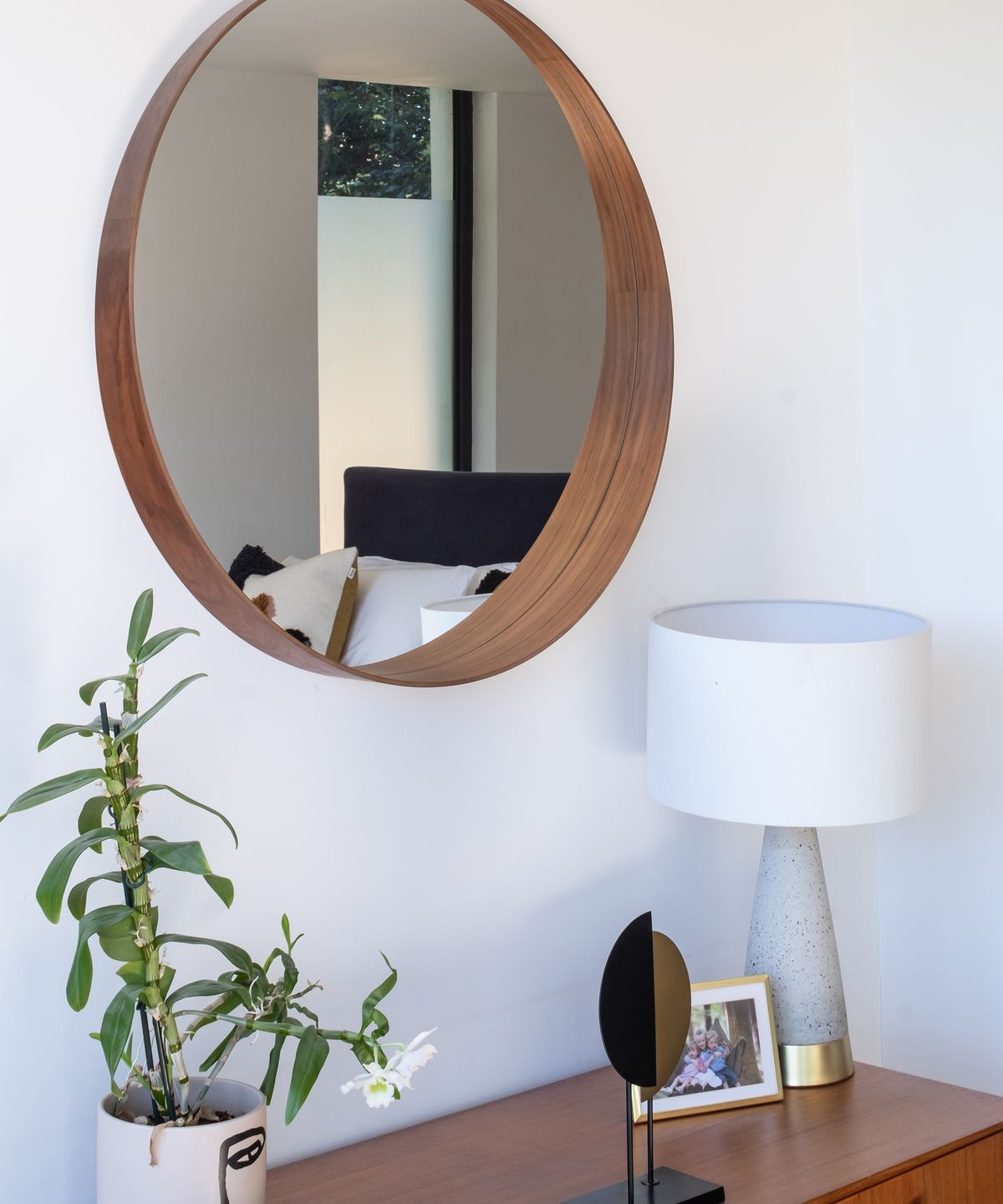 Circular wall mirror in a bedroom