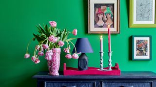 Green painted wall accessorized with brightly colored accents to illustrate the forest green color trend