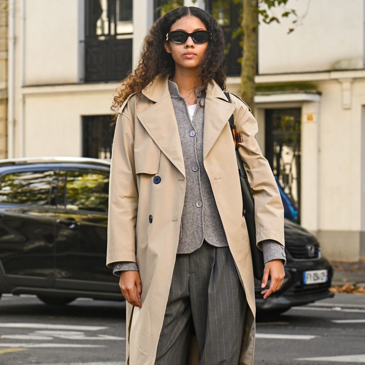 woman wearing trench coat, cardigan, and trousers 