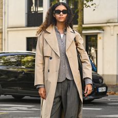 woman wearing trench coat, cardigan, and trousers