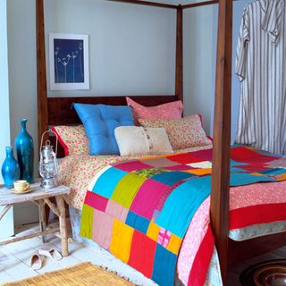 summer bedroom with four poster bed and patchwork bedspread