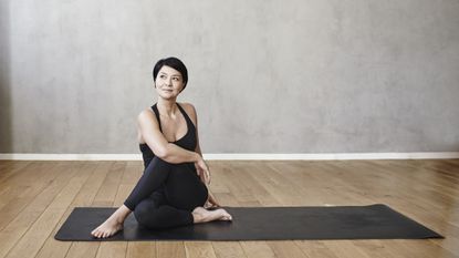 woman on yoga mat doing yoga twist