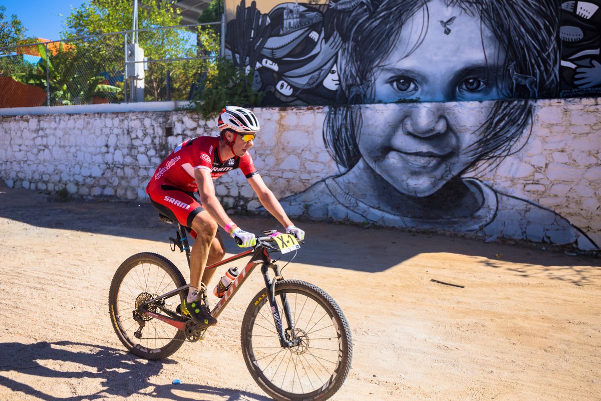 Todd Wells rides past a mural 