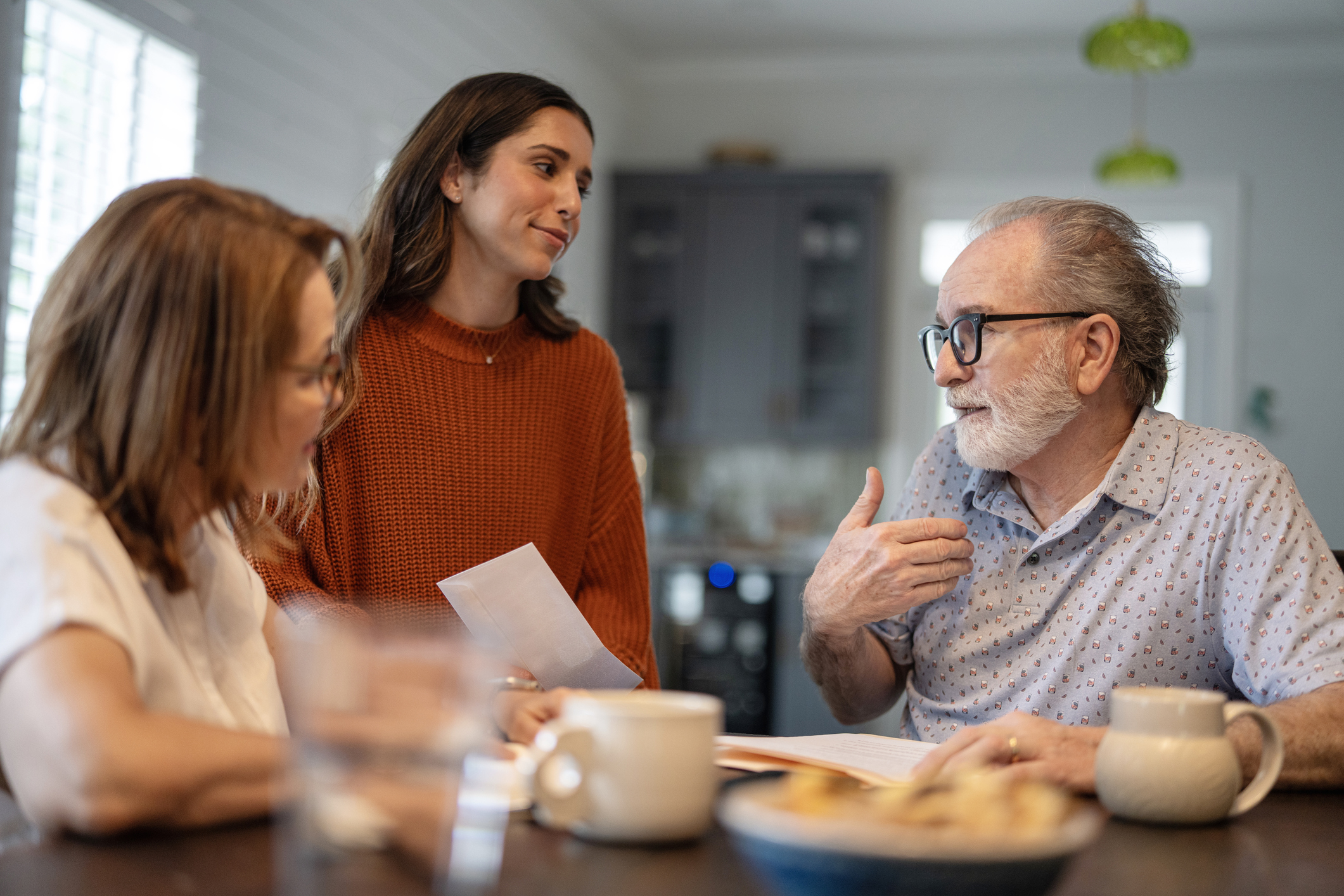 Elderly couple talking with their daughter at home.