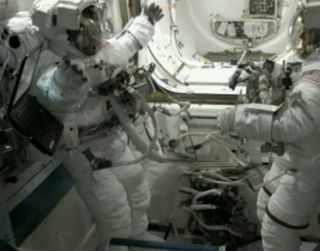 Endeavour shuttle astronaut Mike Fincke (left) stretches his arms while wearing a spacesuit during a spacewalk exercise test on May 25, 2011 before the third spacewalk of NASA's STS-134 mission to the International Space Station. The new excercises help remove nitrogen from spacewalkers' bodies to avoid developing the bends.