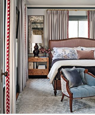 bedroom with pink fabric headboard and blue chair