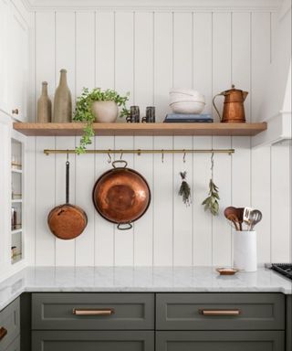 Pans hanging from the wall in a Magnolia kitchen, styled by Joanna Gaines.