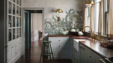 grey green shaker kitchen with dark wooden worktops and green fern printed tile murals