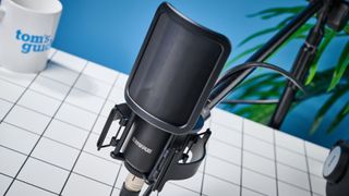 the Shure sm4 condenser musician microphone photographed against a blue background with a physical magnetic pop filter