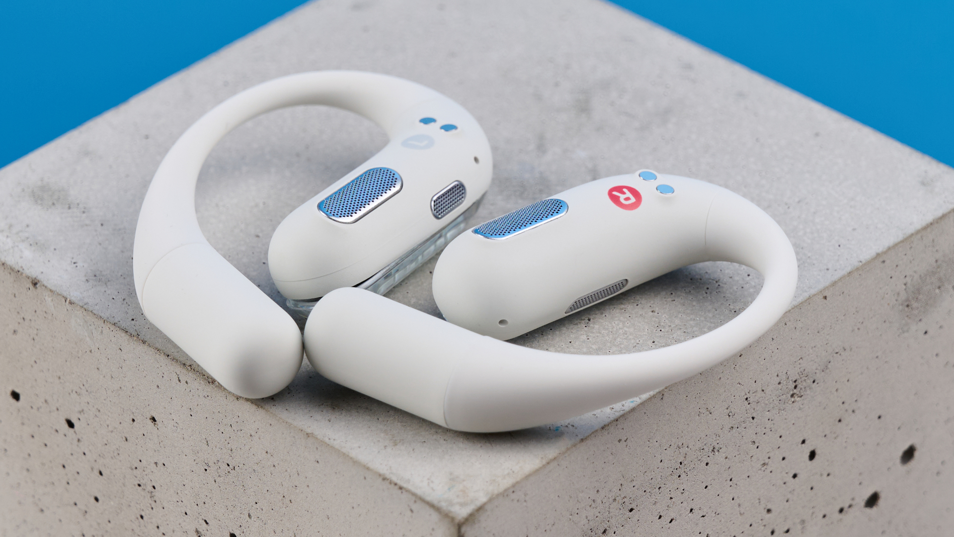 AceFast AceFit Pro open earbuds and the light up charging case photographed in front of a blue background.