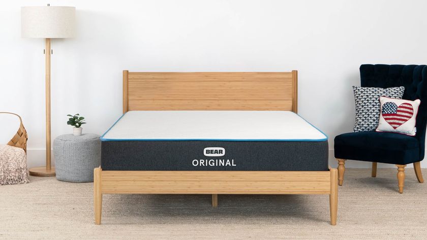 Bear Original Mattress placed on a wooden bedframe next to a black highback chair