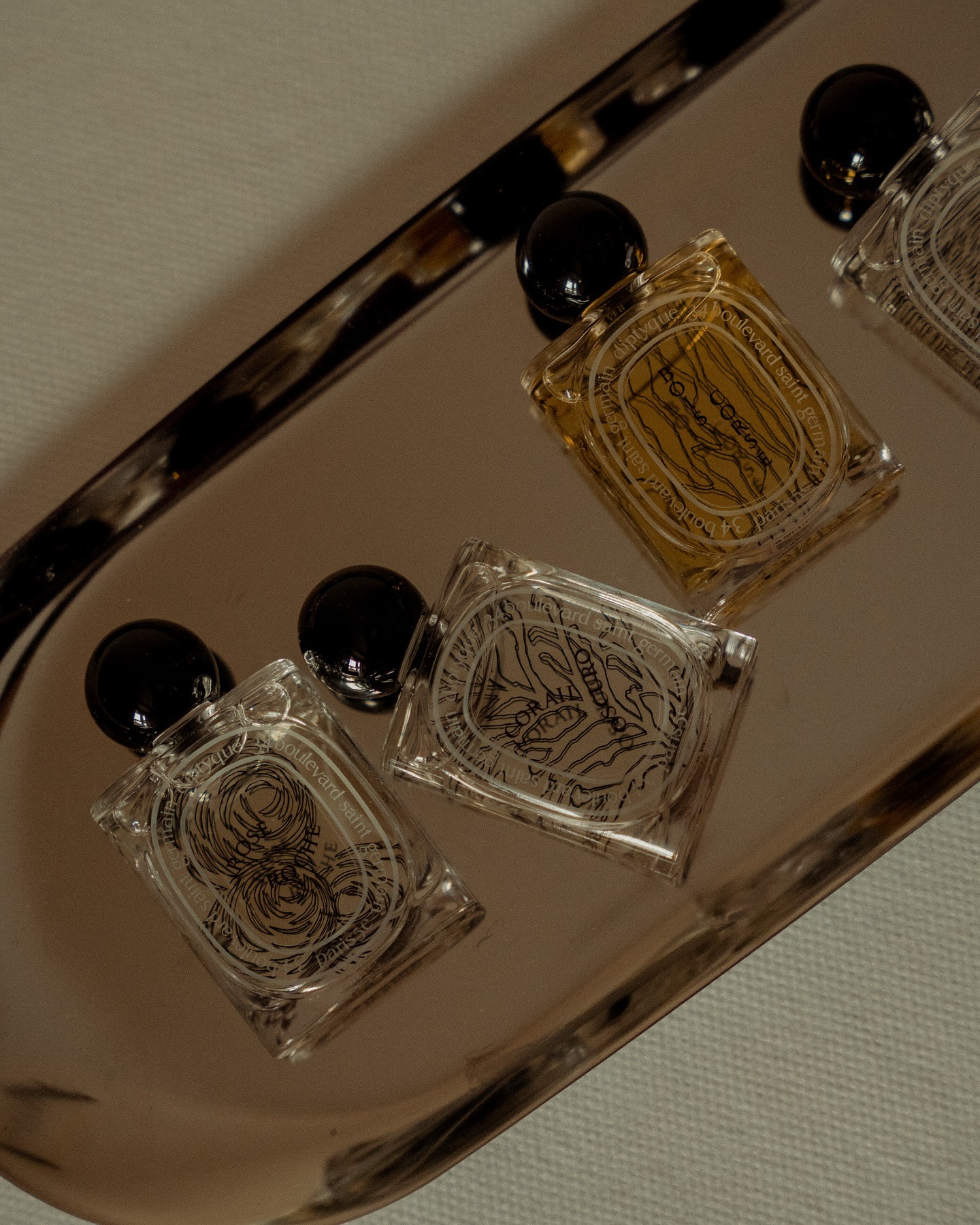 Diptyque perfume bottles on a silver chrome tray