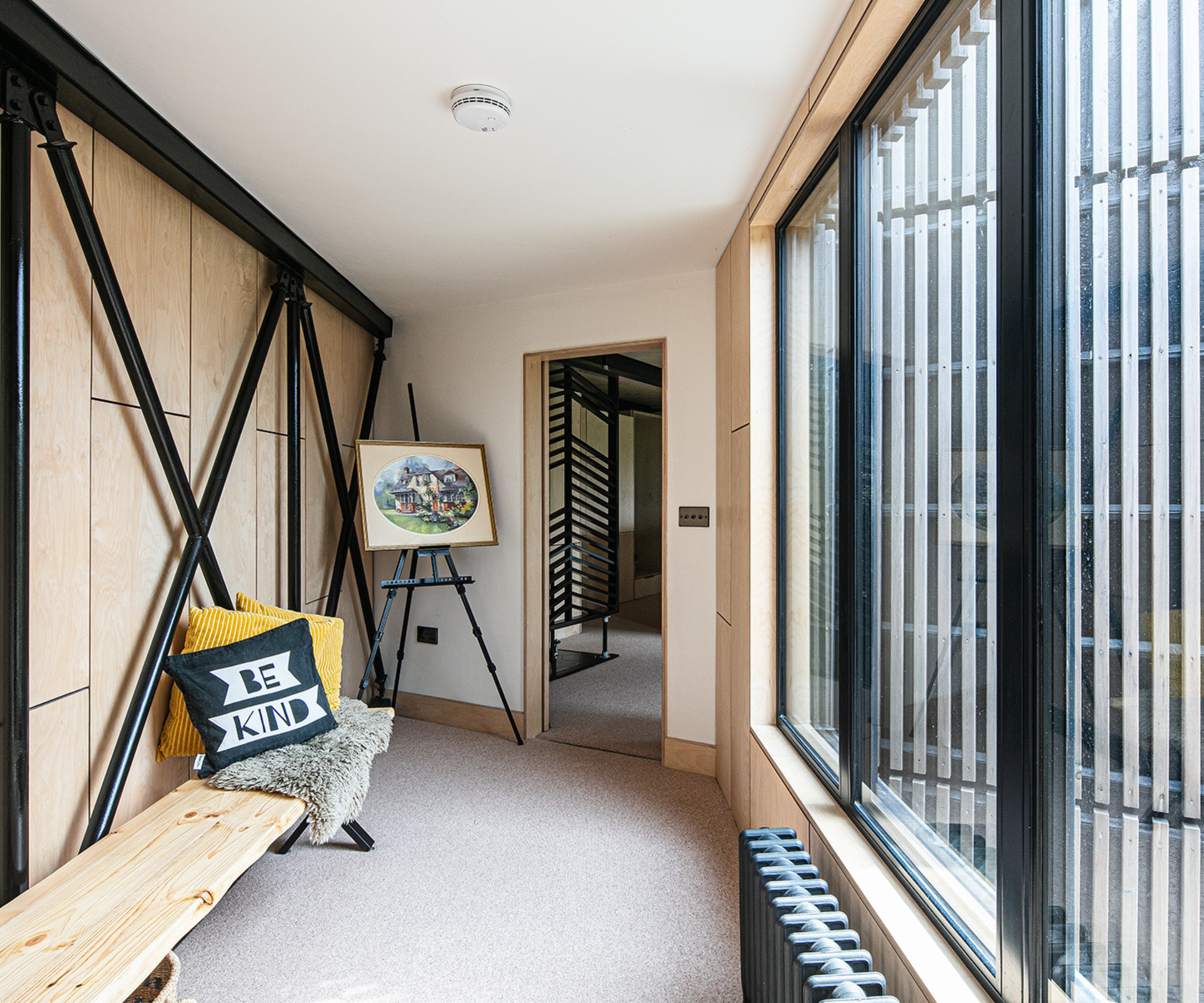 Hallway with steel features, bench, and large window