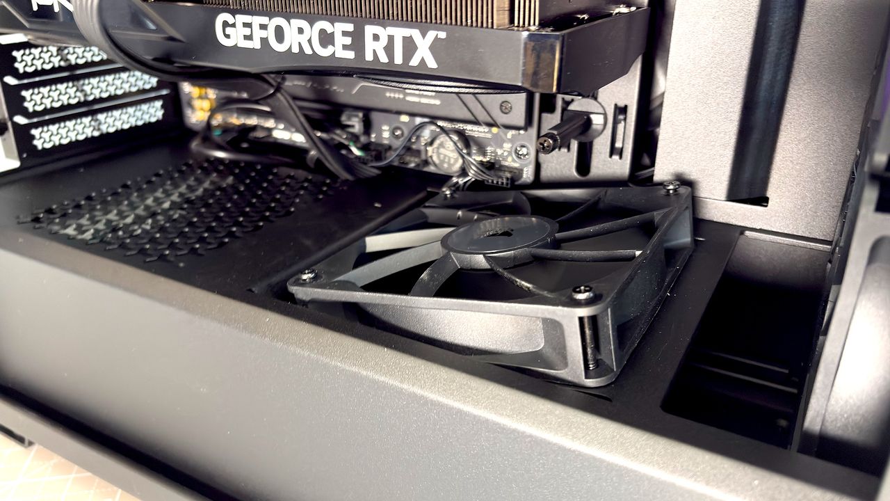 A Corsair PC case, the 3200D, on a desk with various panels removed and ready for a PC build.