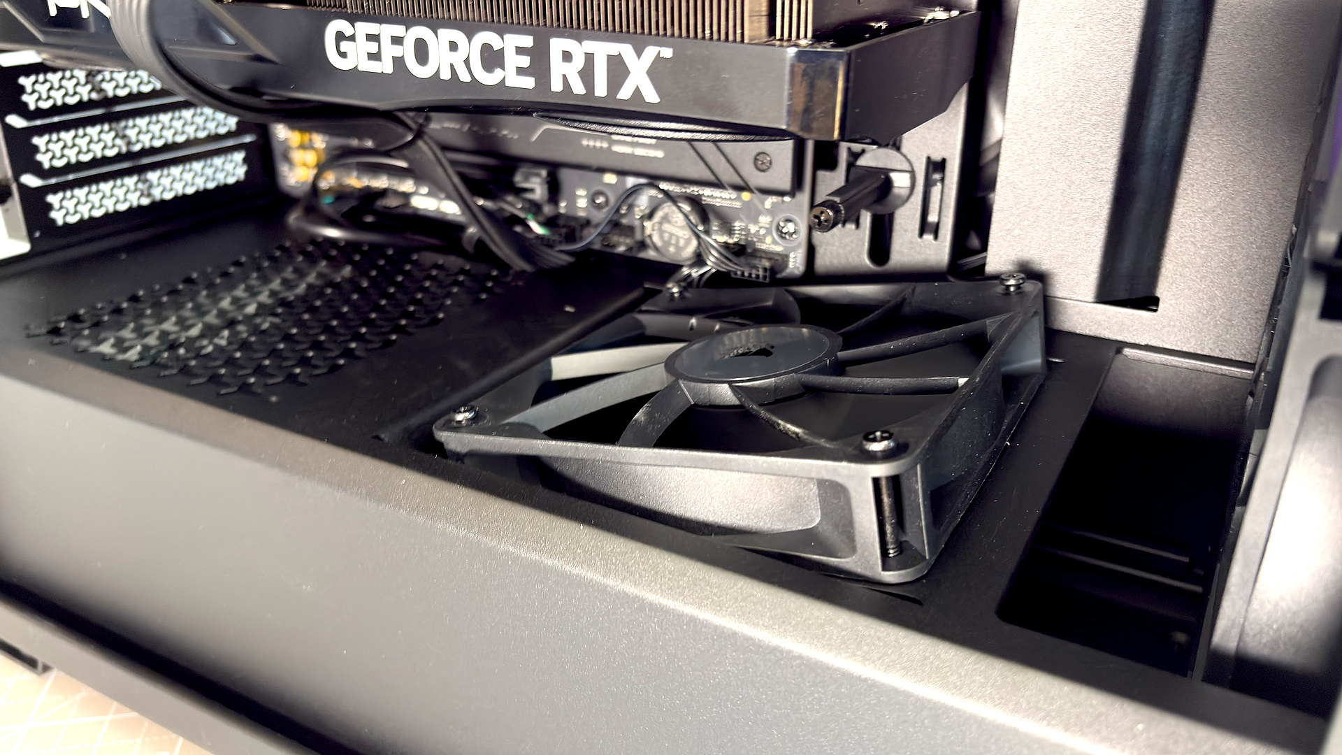 A Corsair PC case, the 3200D, on a desk with various panels removed and ready for a PC build.