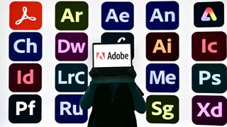 Somebody holding a laptop with the Adobe logo showing on its display in front of icons of different software applications