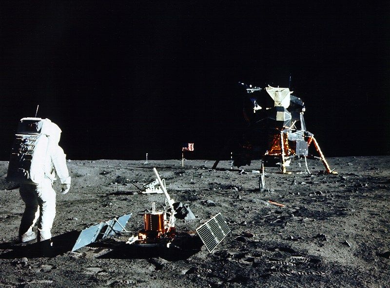 Apollo 11 astronaut Buzz Aldrin unpacks a seismic experiment on the surface of the moon.