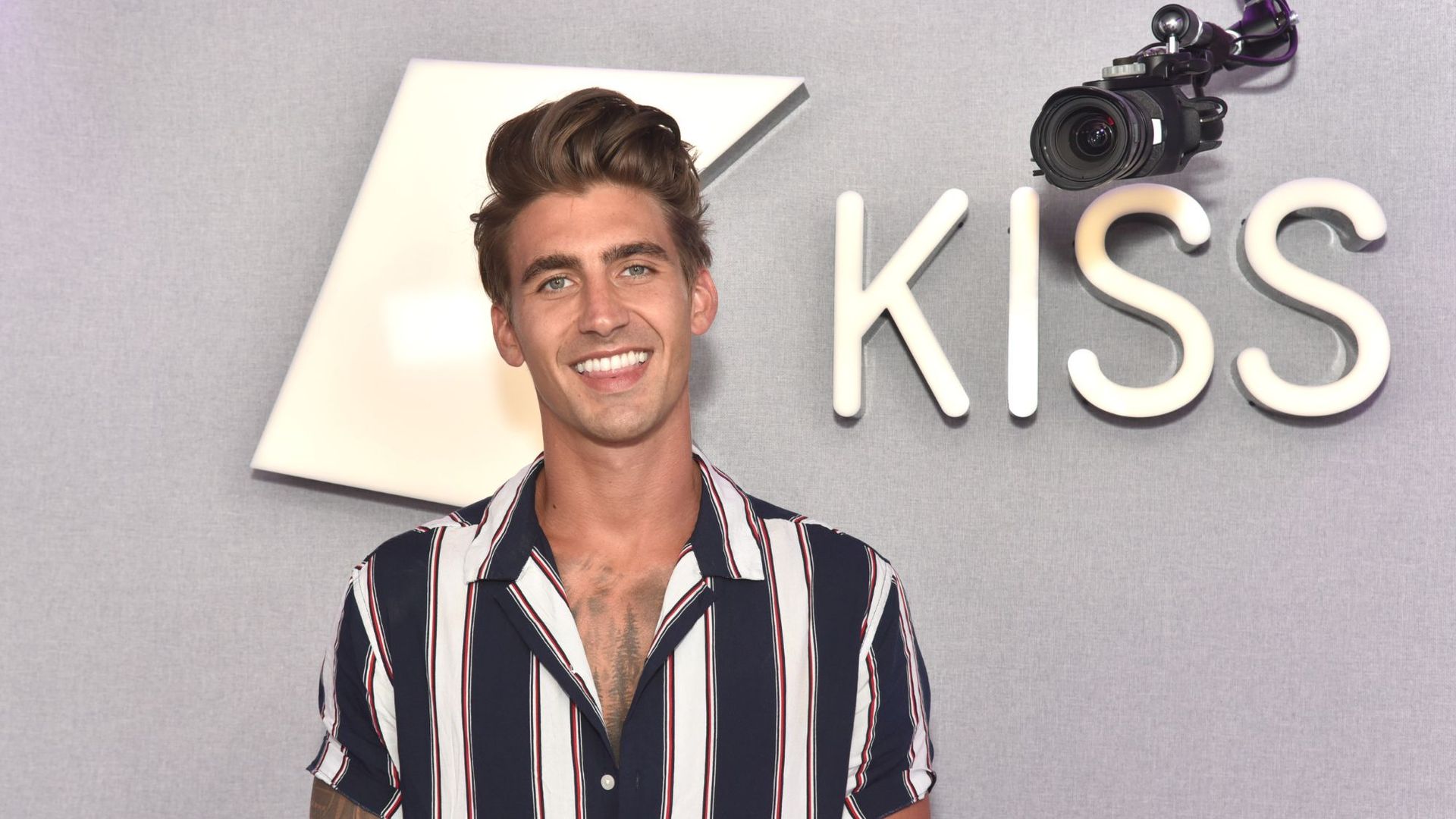 Chris Taylor smiling as he visits Kiss FM