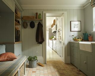 Green boot room that transitions into kitchen space by Sims Hilditch