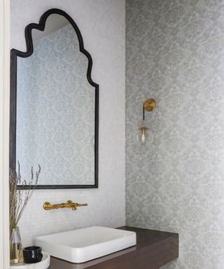 Damask style wallpaper, gold effect fixtures and fittings, floating vanity unit, mirror,