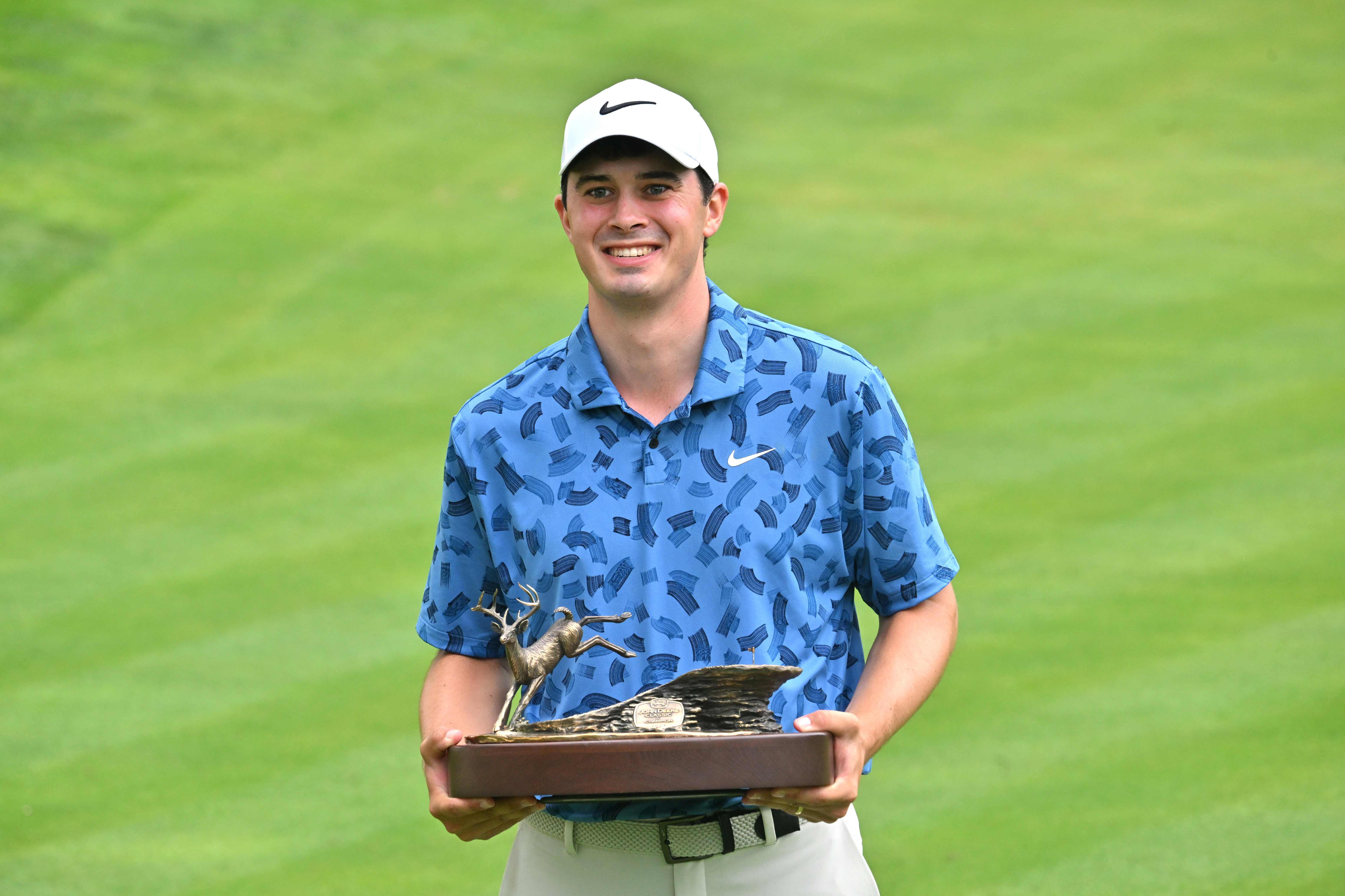 Davis Thompson poses with the John Deere Classic trophy
